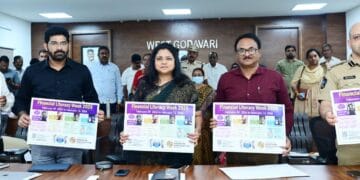 District Collector Chadalavada Nagarani unveiling the Financial Literacy Week 2026 awareness wall poster at the District Collectorate conference hall with officials present.