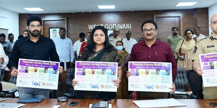 District Collector Chadalavada Nagarani unveiling the Financial Literacy Week 2026 awareness wall poster at the District Collectorate conference hall with officials present.