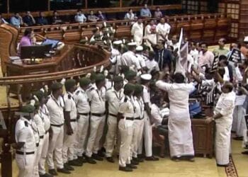 Opposition MLAs protest in the Well of the Kerala Legislative Assembly holding placards over the Sabarimala gold theft probe.