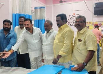 Sukhavasi Srinivas distributing fruits to new mothers at Guntur Government General Hospital during Mohammed Naseer birthday celebrations.