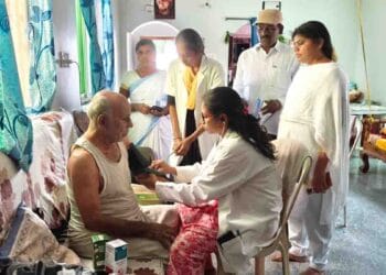 Doctor advising elderly people on heatstroke prevention during village health camp