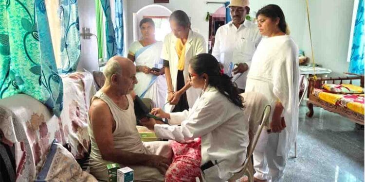 Doctor advising elderly people on heatstroke prevention during village health camp
