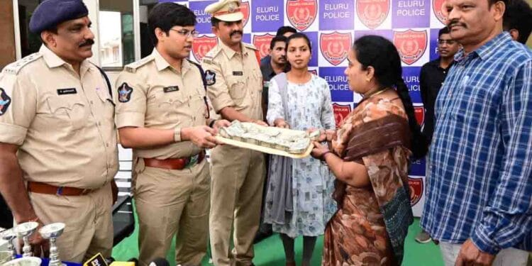 Eluru SP Pratap Shiva Kishore handing over recovered cyber fraud money to victim in Eluru