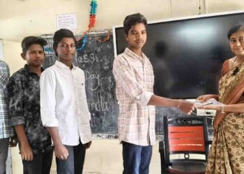 Teacher Janam Sujatha distributing exam kits to Class 10 students at ZP High School Kalikiri