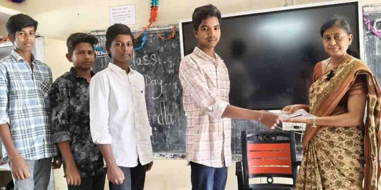 Teacher Janam Sujatha distributing exam kits to Class 10 students at ZP High School Kalikiri