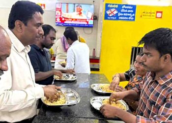 NTR District Collector Lakshmeesha giving laptop to engineering student
